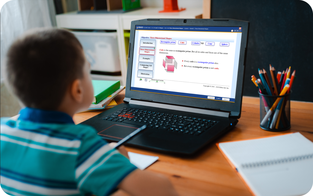 A student sitting at the table is looking at their laptop.